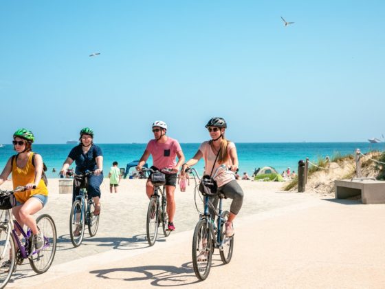 4 pessoas pedalando bikes de aluguel numa bela paisagem